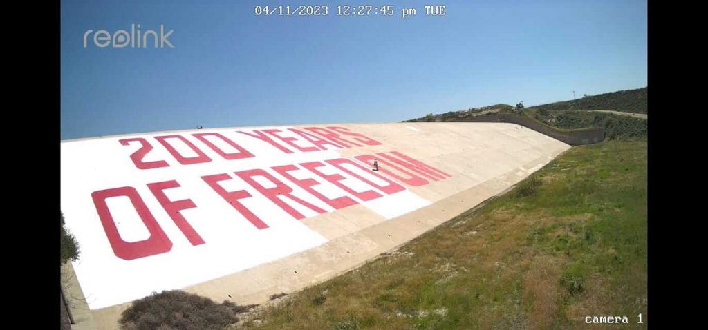 Painting white background around 200 YEARS OF FREEDOM at Prado Dam on April 11, 2023