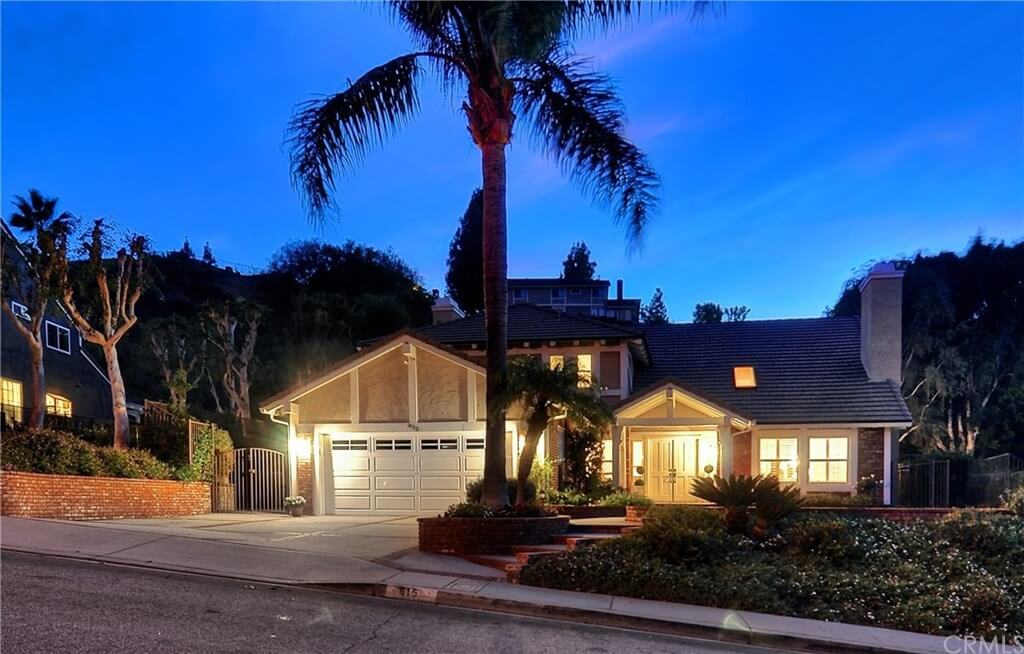 Exterior renovation of a home in Anaheim Hills' Scout Trail HOA. The house features freshly painted siding, fascia, windows, trim, doors, lattice patio cover, rain gutters, entry overhang, chimney top, and eaves in a fresh white color, all done by One Way Painting's team.