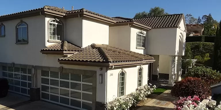 A house in Anaheim Hills freshly painted by One Way Painting, showcasing a clean and modern look with pristine white walls and dark roof tiles.