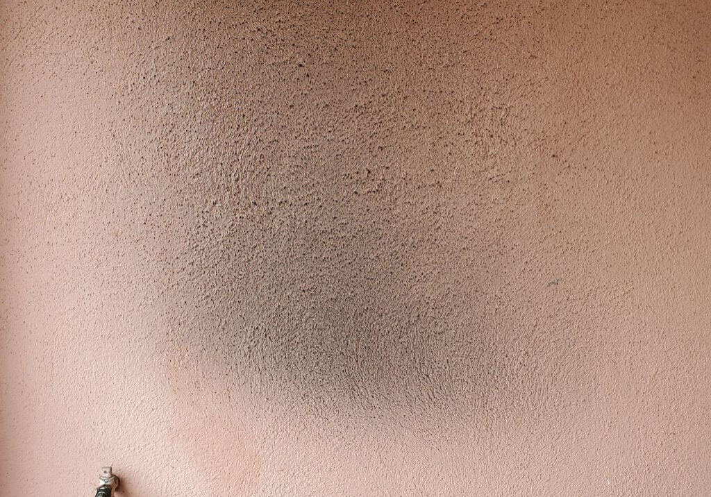 Exterior Stucco Wall in Backyard of a House in Orange, featuring dark black smoke stains from outdoor BBQ.