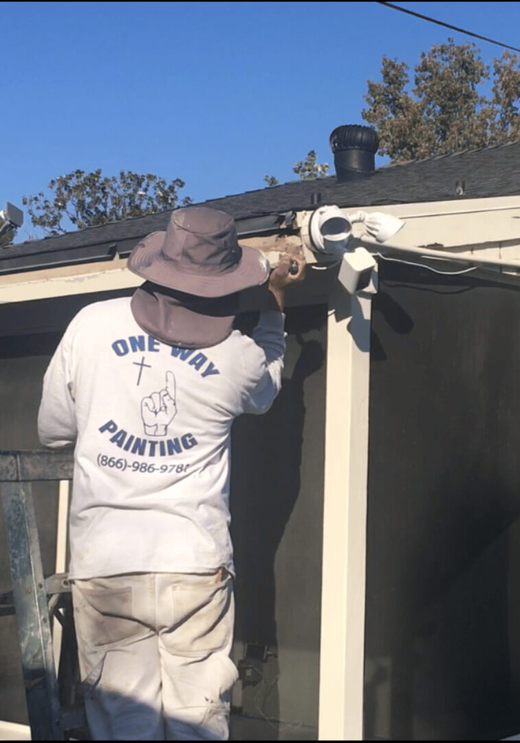 One Way Painting exterior painter removing dry rot from fascia in Santa Ana, Orange County home.